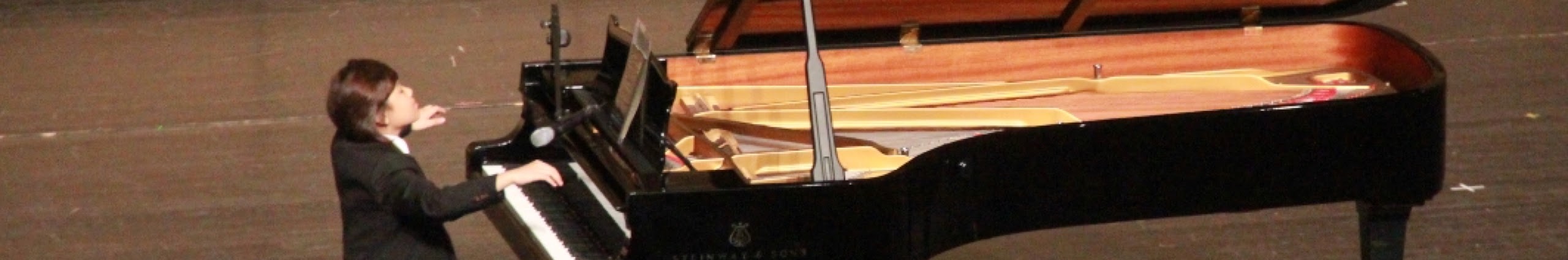 Song-Ze Yu performing at a grand piano on stage